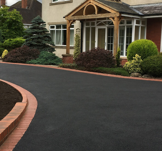 Black tarmac driveway with red brick edging