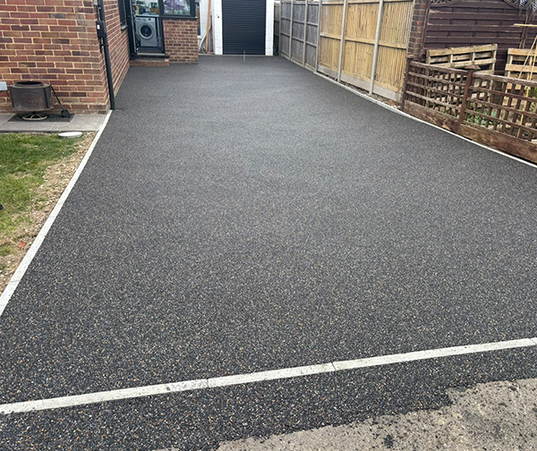 New resin driveway beside a timber fence